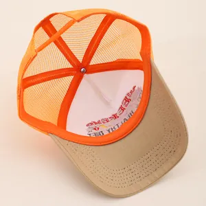 Detailansicht des atmungsaktiven orangen Mesh und verstellbaren Riemens der Trucker Cap