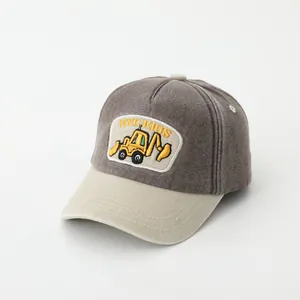 Detail of children's baseball cap featuring a yellow excavator embroidery and HYC KIDS logo