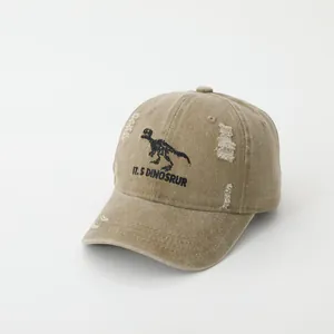 Close-up of khaki baseball cap with dinosaur skeleton embroidery and distressed vintage details