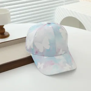 Gros plan sur la casquette tie-dye rose et bleue avec des motifs de papillons blancs