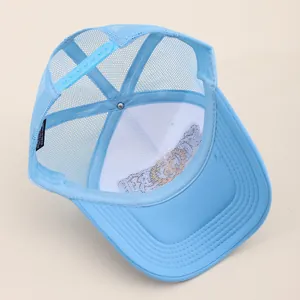 Detail of light blue trucker hat featuring breathable mesh back and adjustable strap