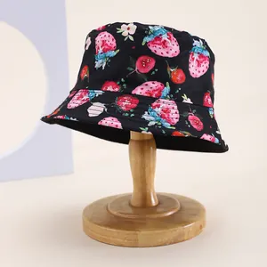 Chapeau bob enfant noir avec imprimé fraises et fleurs sur un support en bois élégant
