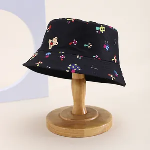 Detail of black cotton bucket hat featuring colorful mushroom and cartoon bear prints