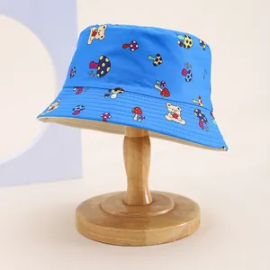 Detailed view of the mushroom and bear print on a blue cotton kids bucket hat