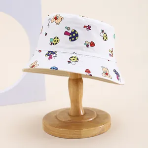 Detail of white cotton bucket hat with sweet bear and mushroom print on a wooden stand