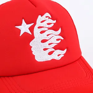 Red trucker hat with white flame star embroidery shown from a 45-degree side angle