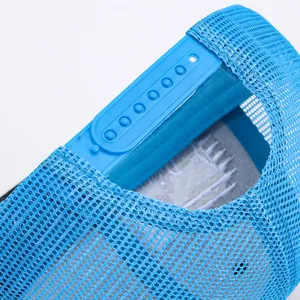Detail of adjustable plastic snapback closure on breathable blue mesh trucker hat