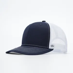 Detail view of navy blue trucker hat featuring white mesh back and contrast stitching