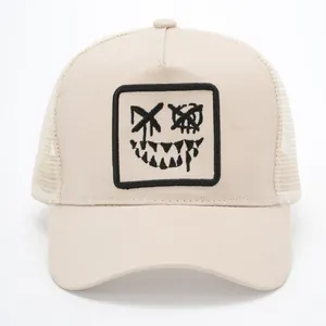 Breathable beige trucker hat with mesh back and embroidered graffiti smiley face patch