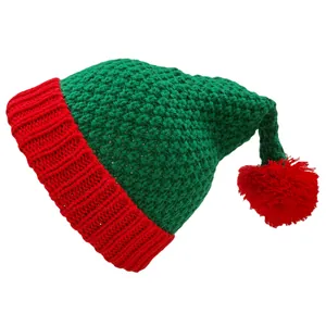 Detail der Strickstruktur einer grün-roten Weihnachtselfenmütze mit flauschigem Bommel