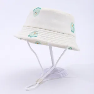 Detail of white cotton baby sun hat with green cartoon chick pattern and adjustable strap