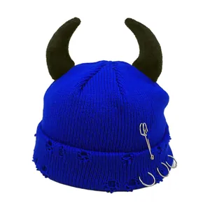 Detail of blue devil horn beanie with punk safety pin and metal rings accents