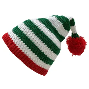 Detail of red and green striped knit Santa elf hat with soft white pompom and texture