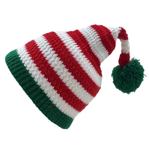 Close-up of red and white striped knit Christmas hat with green pompom and ribbed brim