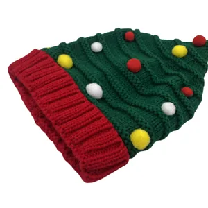 Feestelijke gebreide kerstboom muts met kleurrijke pompons en een rode omslag
