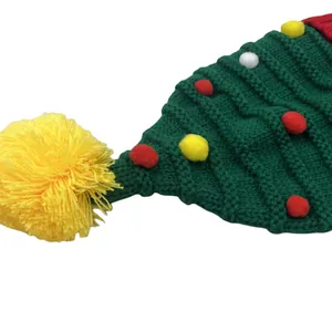 Groene gebreide kerstboommuts met kleurrijke pompons en een gele bal aan de top