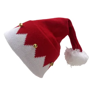 Detalle del gorro de Navidad de punto rojo con pompón blanco y pequeñas campanas de oro