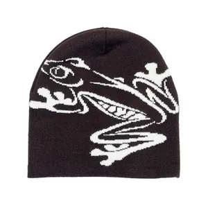 Close-up of fine black knit texture with white abstract frog jacquard pattern detailing