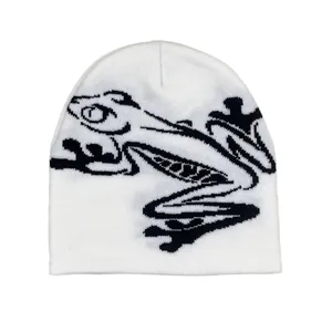 Detail of white knit beanie showing black frog jacquard pattern and premium texture