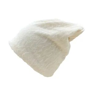 Détail du bonnet en tricot blanc montrant la texture douce et le motif côtelé chaud