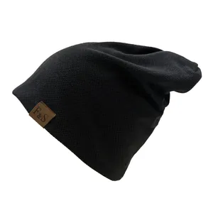 Close-up of fine knit texture and brown faux leather F&S logo tag on a black beanie hat