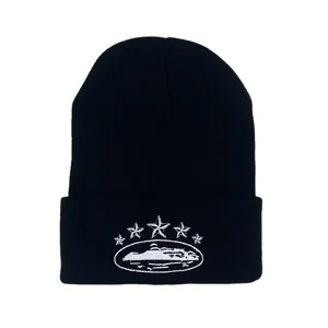 Black knitted beanie featuring white star embroidery and cuffed design for streetwear style