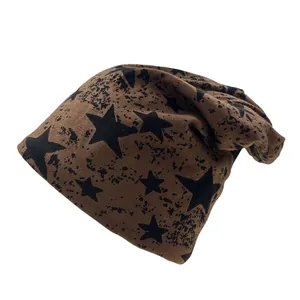 Detailed knit texture of a slouchy coffee brown beanie with black star and ink splash patterns