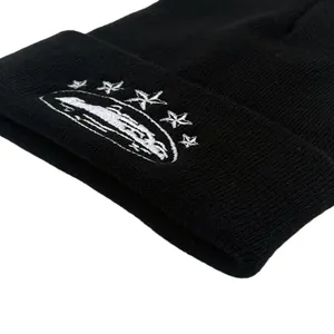 Streetwear black knit beanie with white star embroidery shown in a detailed close-up shot
