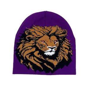 Close-up of deep purple knit beanie featuring a detailed lion head jacquard pattern