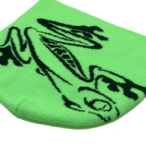 Flat lay of a neon green knitted beanie with black street style jacquard frog patterns