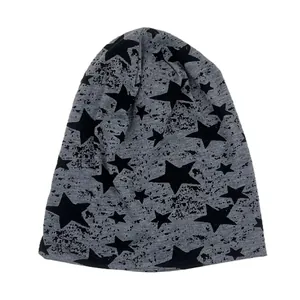 Grey knitted slouchy beanie with black star patterns and ink-splatter texture design