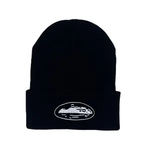 Detailed close-up of white landscape embroidery on a black knit street fashion beanie