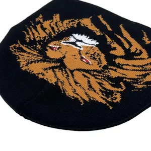 Detail of black knit beanie featuring a bold orange lion jacquard punk art pattern