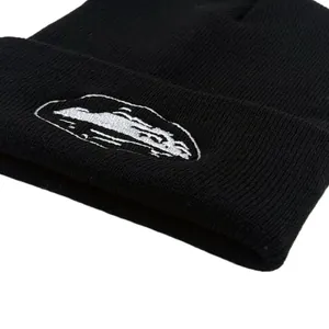 Close-up of high-quality white landscape embroidery on a black ribbed knit beanie hat