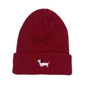 Detail shot of a ribbed burgundy knit beanie with a cute white dog embroidery
