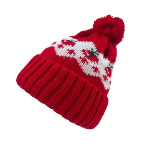 Dettaglio del cappello in maglia Fair Isle con motivi a ciliegia e un grande pompon rosso