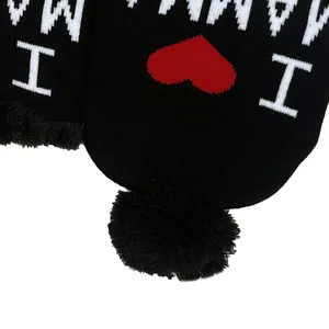 Dettaglio cappello in maglia bimbo con motivo I love MAMMA e pompon in pelliccia