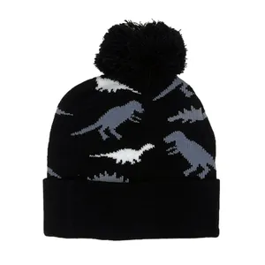 Kids knitted dinosaur beanie featuring a black pom pom and cute graphic patterns