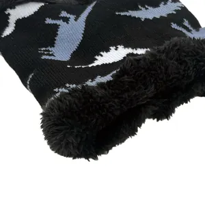 Detail of winter knitted hat showing warm black faux fleece lining and dinosaur pattern