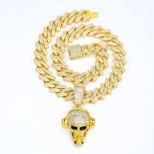 Macro detail of gold hip hop Cuban chain with pave crystal headphone skull pendant