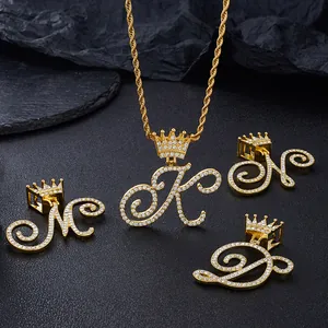 Macro detail of micro-paved zircon iced out crown letter pendants with gold rope chain