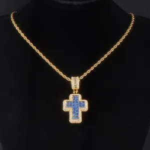 Dettaglio del ciondolo a croce hip hop con pietre blu e catena a fune dorata