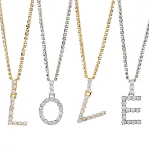 Detail van LOVE letterhangers aan sprankelende tenniskettingen in goud en zilver