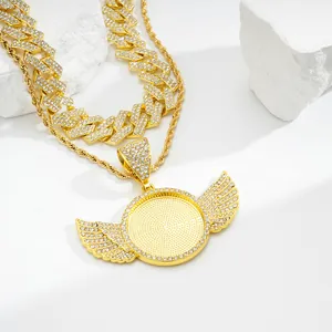 Close-up of gold-plated hip hop wing pendant with sparkling crystals and double chains
