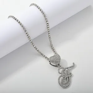 Macro shot of silver letter F iced out pendant on shimmering heart tennis chain