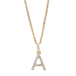 Detail van de goudkleurige tennisketting met met stenen bezette letter A hanger