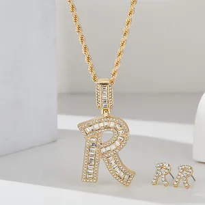 Dettaglio del set collana e orecchini con lettera R placcati in oro con zirconi lucidi