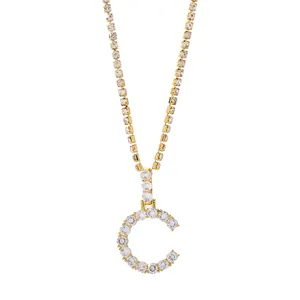 Detail van gouden letter C hanger met fonkelende zirkonia op een tennis ketting