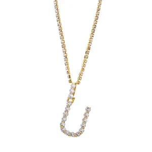 Detailopname van vergulde letter J hanger aan een tennisketting met witte zirkonia