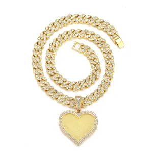 Close-up of golden Cuban link necklace with iced out heart pendant and sparkling zircons